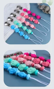 Detail view of silicone rose bead pacifier clips with metal fasteners and nylon loops