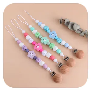 Pack of 4 silicone and beechwood baby pacifier clips with floral teether in pastel colors