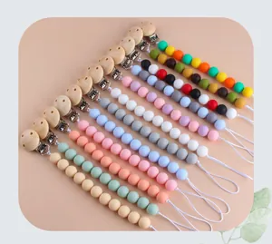 Detail von Schnullerketten aus Silikonperlen mit Naturholz-Clips in verschiedenen Farben