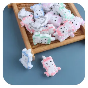 DIY cartoon unicorn silicone beads in macaron colors on a tray for pacifier clips