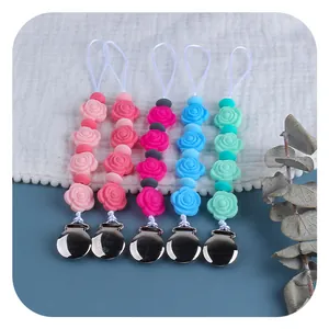 Silicone rose bead pacifier clip set in five colors on a textured waffle fabric background