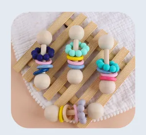 Detail van vier babyrammelaars van hout en silicone met kleurrijke sensorische kralen