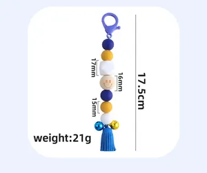 Detailed view of DIY beaded keychain with silicone beads, bell, and leather tassel