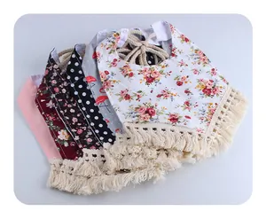 Detail view of cotton baby bibs set featuring flamingo and floral prints with tassel trim