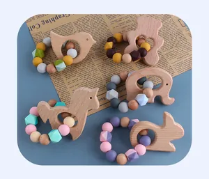 Detail view of five beech wood animal teethers with colorful silicone beads on blue backdrop