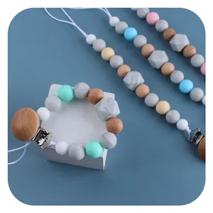 DIY Baby Schnullerketten aus Silikon und Buchenholz in Pastellfarben auf blauem Grund