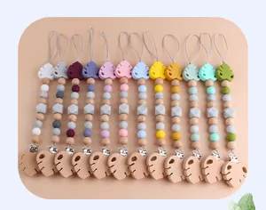 Flat lay of colorful beech wood and silicone leaf pacifier clips in various pastel tones