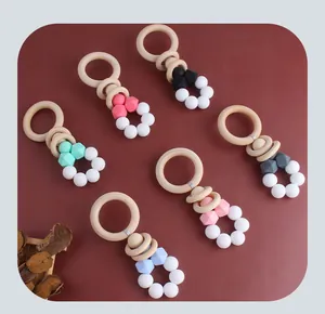 Flat lay of colorful baby teethers with natural beech wood rings and silicone beads