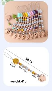 Close-up of baby pacifier clip showing colorful silicone beads and beech wood leaf clip