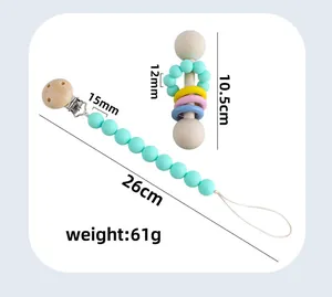 Detail of wooden baby teether rattle and mint green silicone pacifier clip set with sizes