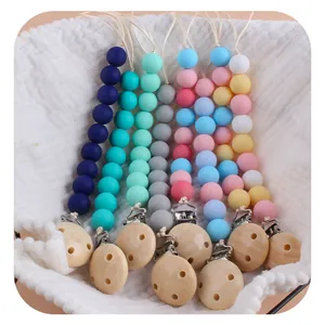 Handmade silicone and wood baby pacifier clip set with colorful beads on waffle texture