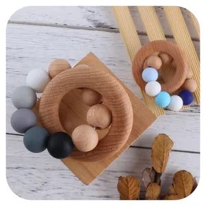 Baby teething rings set with natural beech wood and macaron silicone beads on white wood