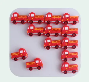 Vista plana de cuentas de silicona con forma de camión de bomberos para chupetes DIY