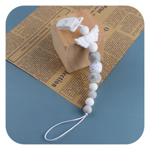 Baby Schnullerkette mit Engelsflügeln und Silikonperlen auf Vintage-Hintergrund