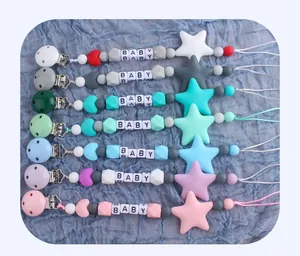 Detail view of silicone baby pacifier clips in various pastel colors with star and moon beads
