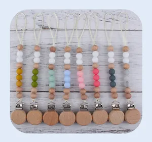 Flat lay of colorful beech wood and silicone baby pacifier clips in various color schemes