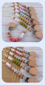 Detail of wooden pacifier clip with silicone beads on vintage background