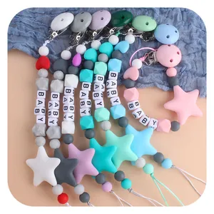 Colorful silicone baby pacifier clips with star and heart beads on a soft background
