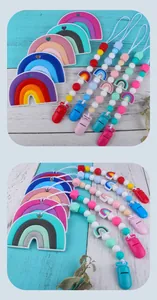 Dettaglio di clip per dentizione arcobaleno in silicone e catenelle con perline per neonati