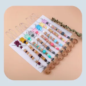 Detail of baby pacifier clips featuring cartoon elephant silicone pendants and wooden beads