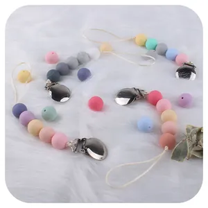 Catenelle portaciuccio in silicone macaron con clip metalliche su ecopelliccia bianca