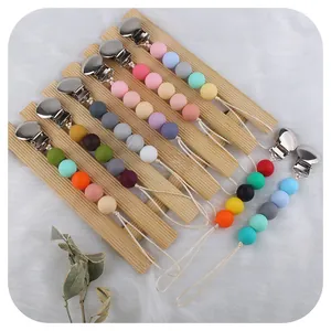 Catenelle per ciuccio in silicone con clip tonde in metallo e perline macaron su legno