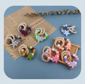 Detailed view of colorful silicone star teething bracelets with natural wooden rings