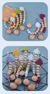 Detail of colorful silicone leaf pacifier chains with beech wood clips on blue backdrop