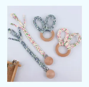 Détail d'attaches-tétines en hêtre et anneaux de dentition oreilles de lapin avec fleurs