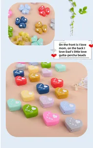 Dettaglio macro di perline in silicone a cuore con scritte MOM e DAD per massaggiagengive