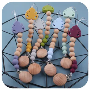 Silicone leaf baby pacifier clips made with beech wood beads in a stylish metal basket