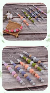 Detail of colorful silicone and wooden beads for baby teething necklace on wood background