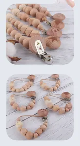 Close-up of wooden pacifier clips with engraved cartoon animal icons and round beads