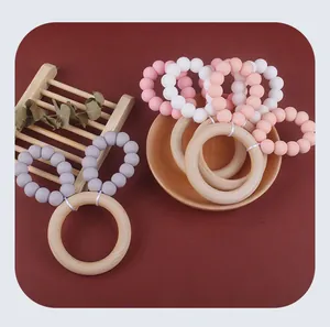Close-up of baby teether ring with natural beech wood and pastel silicone rabbit ears