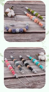 Detail of silicone and wood teething necklaces with geometric beads and safety clasps