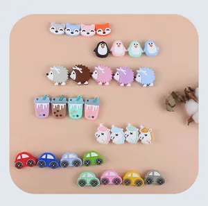 Vue à plat de perles de dentition en silicone colorées en formes de renard, pingouin et voiture