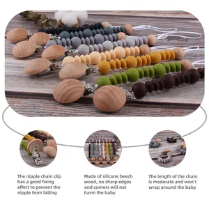 Silicone and beech wood baby pacifier clip chain in various colors on wooden background