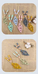 Detail of silicone leaf teething necklaces with colorful beads and natural wood accents
