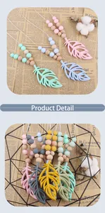 Detail of silicone feather teething necklace with colorful beads and wooden rings