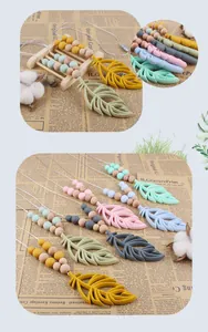 Detail of leaf-shaped silicone baby teether with wooden beads and safety breakaway clasp