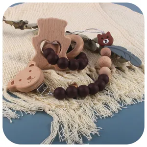 Beißring-Set aus Buchenholz mit Silikon-Schnullerkette auf einer Quastendecke