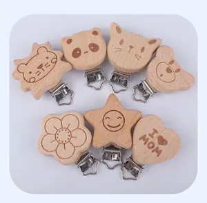 Detail of 7 beech wood pacifier clips with panda and heart shapes on white background