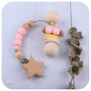 Set de dentición para bebé con cadena de silicona y sonajero de madera sobre madera suave