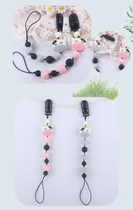 Detalle del sujetachupete de silicona con diseño de vaca y cuentas de colores para bebés y niños