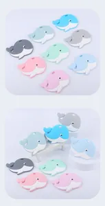 Detail of whale-shaped silicone baby teethers in seven pastel colors with hanging holes