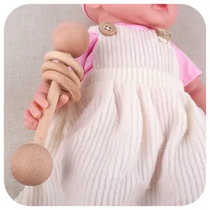 Handcrafted beech wood baby rattle with rings and cute doll in striped overalls
