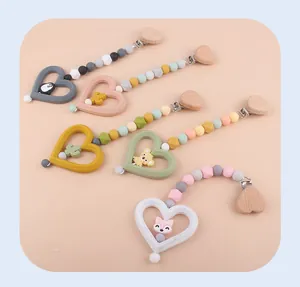 Dettagli di clip in legno a cuore e perle in silicone su catenelle per ciuccio