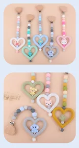 Dettaglio catenella portaciuccio in silicone con clip cuore in legno e ciondoli animali