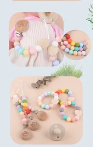 Macro detail of silicone pacifier clip with heart wooden beads and LOVE engraving