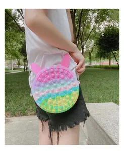 Detail of round rainbow silicone pop purse with rabbit ears and metal chain strap